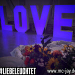 XXL LOVE Buchstaben leuchtend in der Farbe blau bei einer Hochzeit als Deko aufgestellt