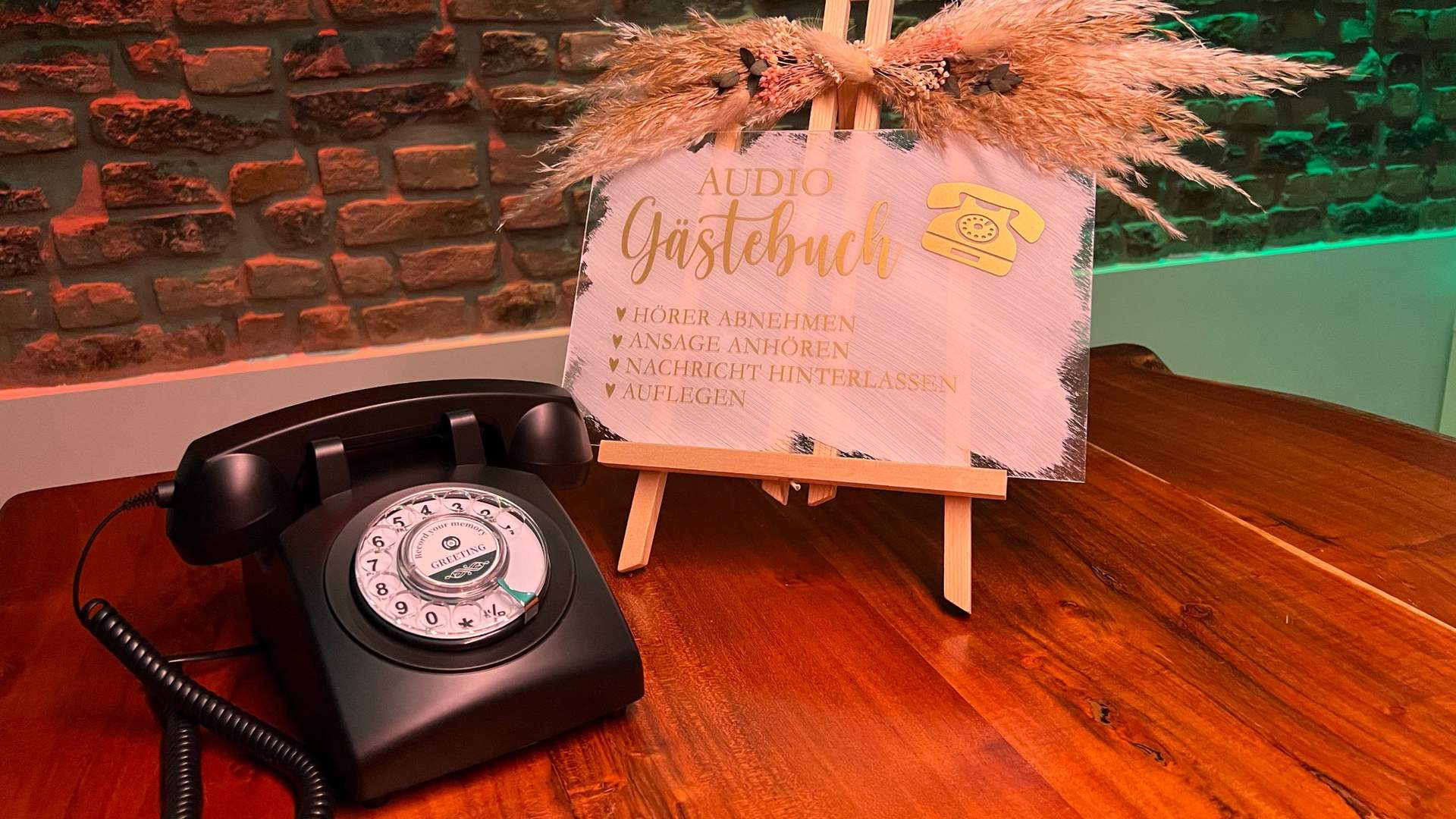 Audio-Gästebuch mit Retro-Telefon und Staffelei mit Schild in einer Location