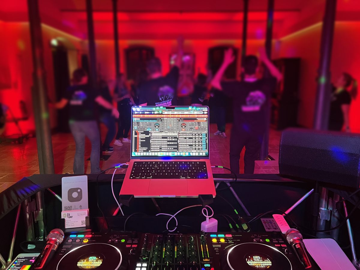 Blick über das DJ-Pult von DJ mcJay auf die Tanzfläche einer Firmenfeier auf der Burg Reichenstein